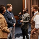 A diverse group of businessmen in corporate attire having a conversation indoors.