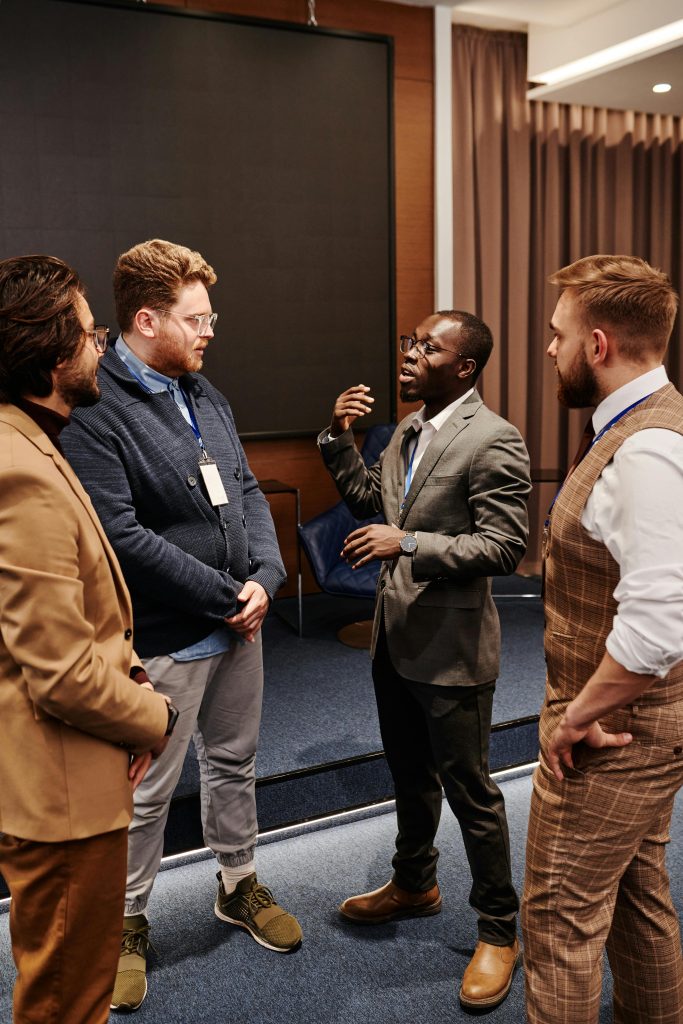 A diverse group of businessmen in corporate attire having a conversation indoors.