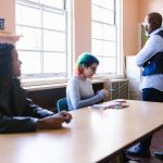 Teacher and students engaged in a classroom discussion with natural light.