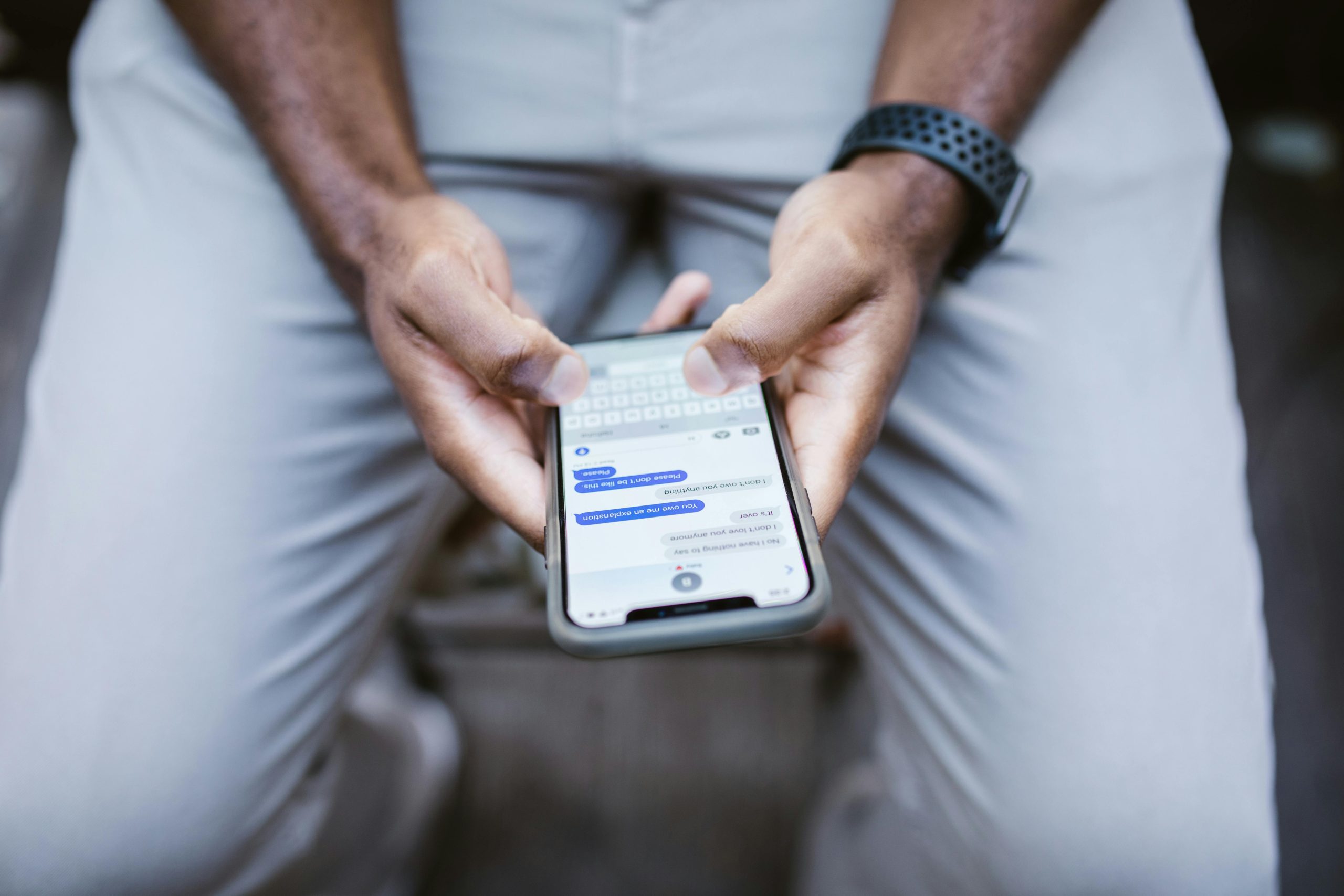Close-up view of a man texting on a smartphone, capturing communication in action.